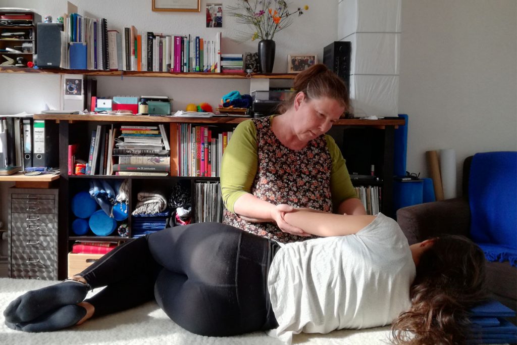 Luka Skywalkerin hält den Arm einer auf der Seite liegenden Patientin